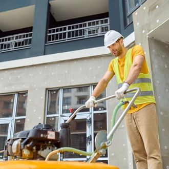 Ein Mann reinigt den Boden auf einem Bau mit professioneller Ausrüstung
