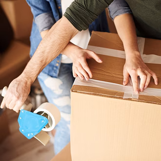 Ein Paar das einen Umzugskarton zuklebt