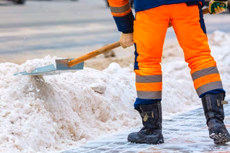 Mitarbeiter von Purexa fegt im Winter Schnee von der Strass und beseitigt Schnee.